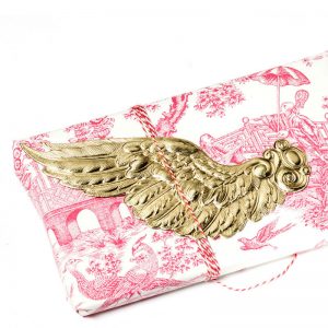 Geschenkverpackung mit goldenem Flügel